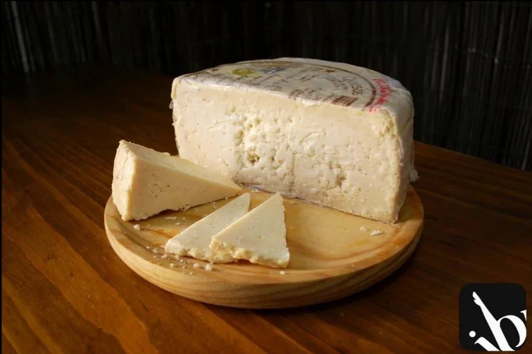 Queso artesanal curado en cuñas sobre tabla de madera